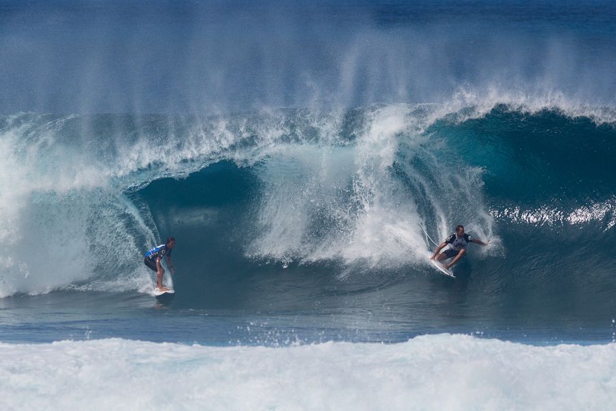 Surfers sharing a wave in North Shore, Hawaii