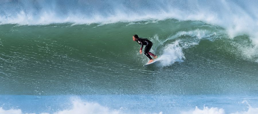 Surfer surfing Supertubos wave